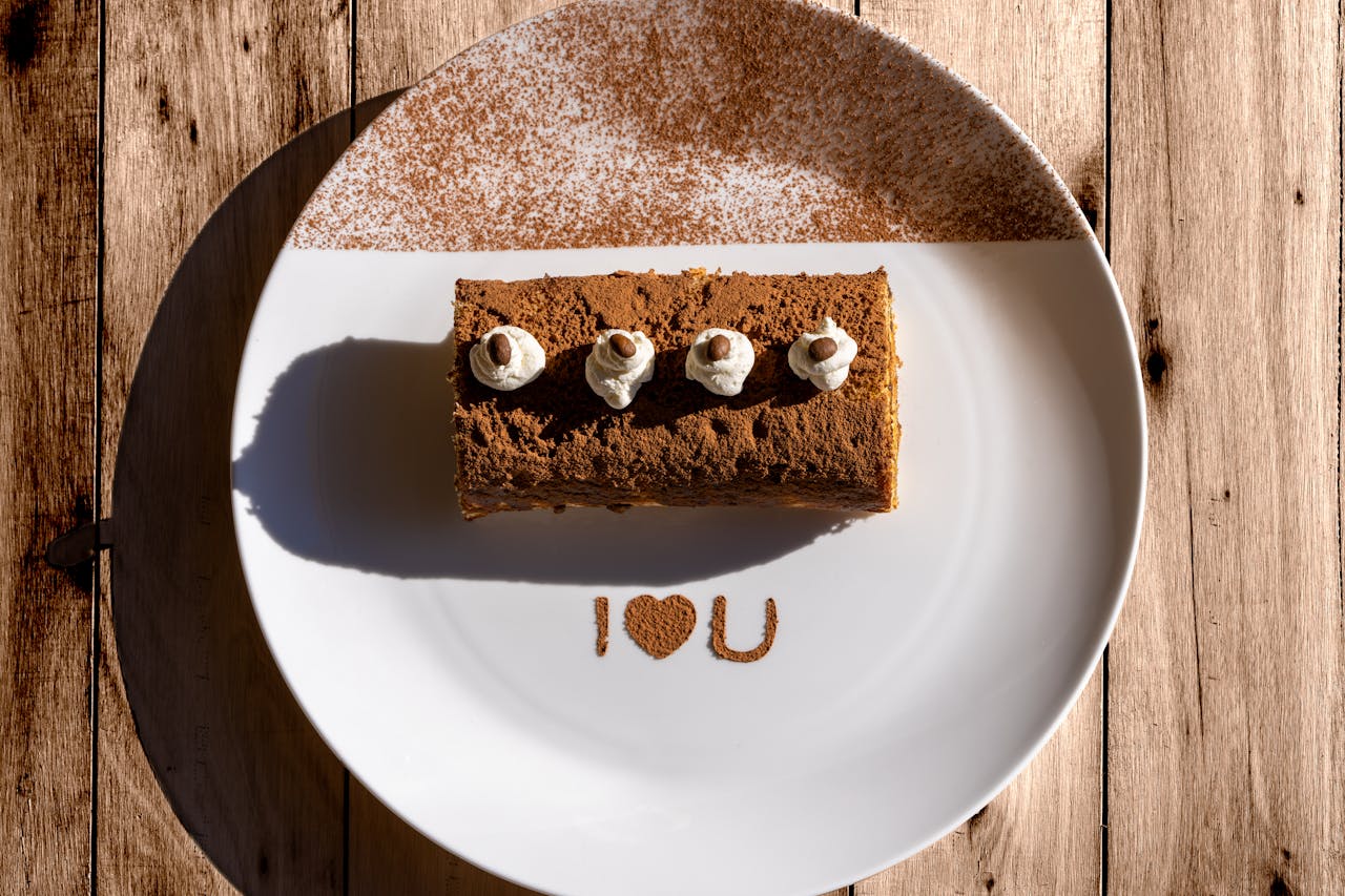 Delicious tiramisu with 'I ❤️ U' message on a sunlit plate, perfect for Valentine's Day.