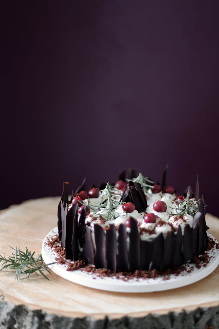 Delicious chocolate cake topped with cream and red berries, perfect for dessert lovers.